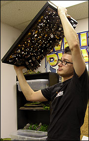 Picture of Ty Finocchiaro holds the display tray over his head to show how strong the magnets are.