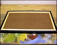 Picture of the inner frame and hardboard sitting in the picture frame.